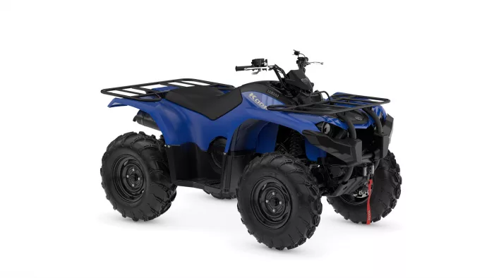 Blue Yamaha ATV with black front and rear racks on a white background in a side-angle view.