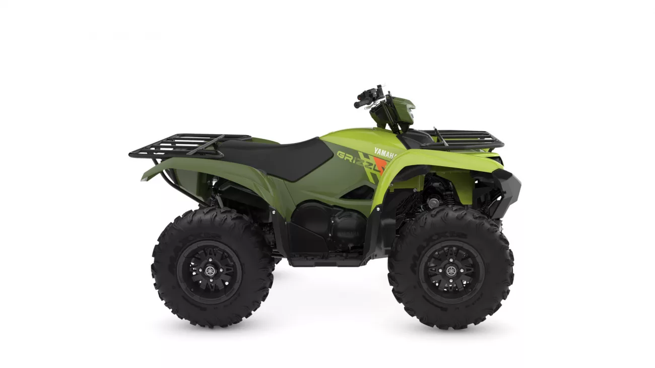 Green Yamaha ATV with large knobby tires and front/rear cargo racks, shown in side profile.