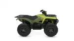 Green Yamaha ATV with large knobby tires and front/rear cargo racks, shown in side profile.