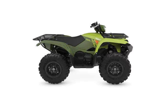 Green Yamaha ATV with large knobby tires and front/rear cargo racks, shown in side profile.