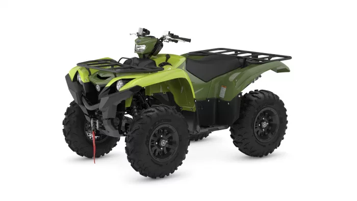 Green all-terrain vehicle (ATV) seen from a front-left angle with large knobby tires and front/rear racks
