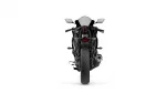 Rear view of a black sport motorcycle with red tail light and silver exhaust against a white background.