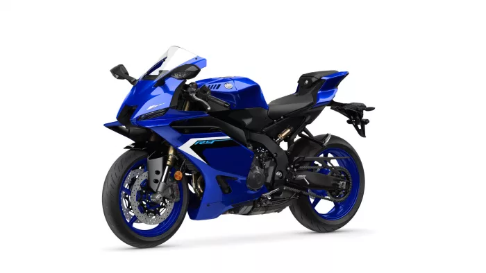 Blue sport motorcycle shown from a front-left angled view, featuring a blue fairing and black frame with a clear windscreen and disc brakes.