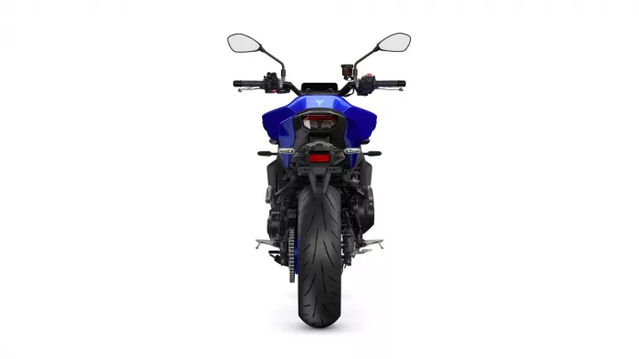 Rear view of a blue sport motorcycle with mirrors, taillight, and wide rear tire against a white background, showing the bike’s silhouette.