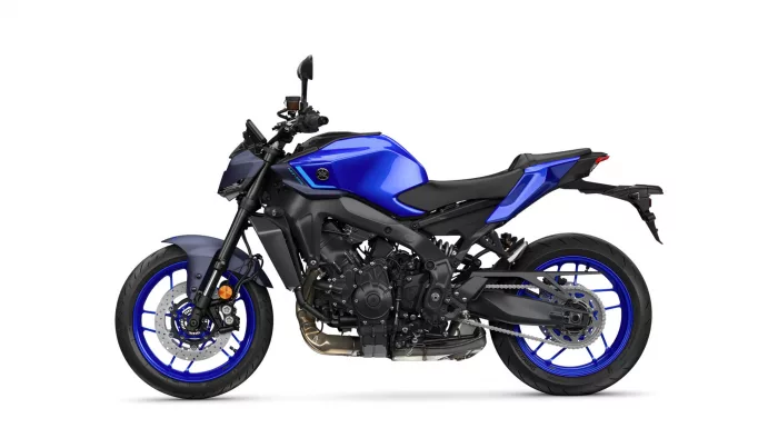 Blue sport motorcycle in side view, showing its blue fuel tank, black frame, and blue rims with disc brakes on the front wheel.