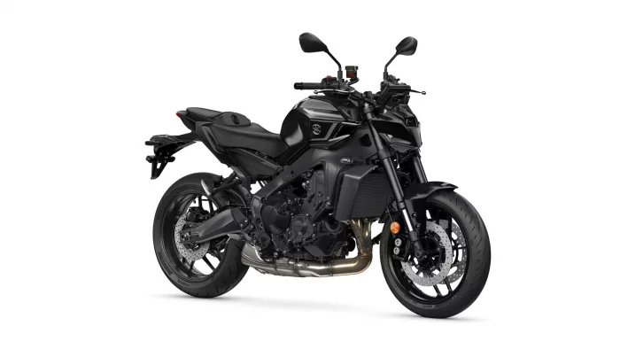 Black sport motorcycle photographed on a white background, angled to show its side profile and engine details (exposed exhaust and frame).