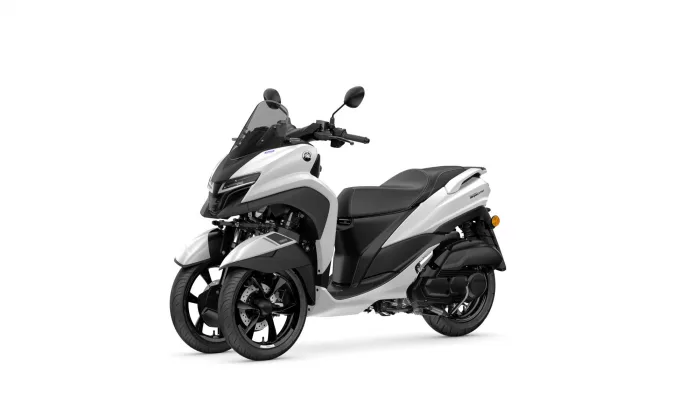 White Yamaha Tricity three-wheeled scooter with windshield and black seat.