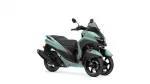 Front-three-quarter view of a teal Yamaha scooter with two front wheels and a tall windscreen, black seat and handlebars.