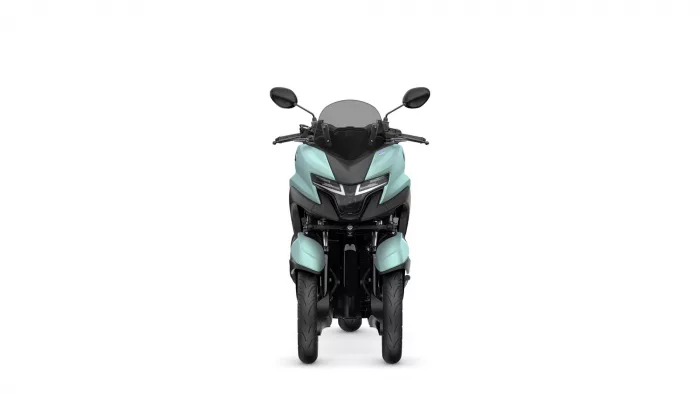 Front view of a teal motorcycle with a dark windscreen and black handlebars, seen head-on.