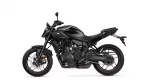 Side view of a black sport motorcycle with exposed engine and disc brakes on a white background.
