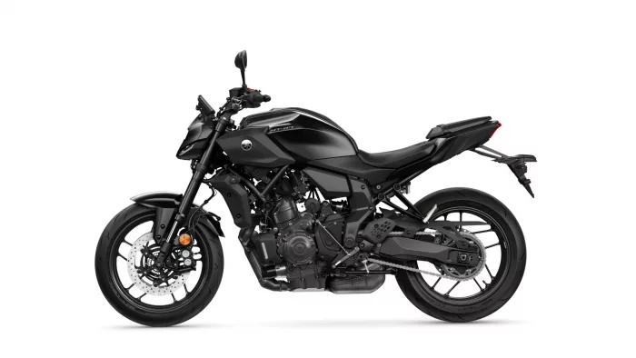 Side view of a black sport motorcycle with exposed engine and disc brakes on a white background.