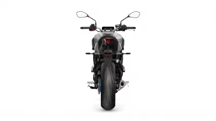 Rear view of a gray sport motorcycle with a red taillight and wide rear tire.