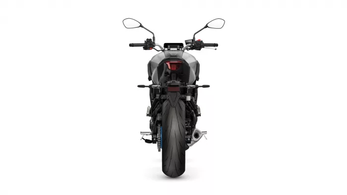 Rear view of a gray sport motorcycle with a red taillight and wide rear tire.