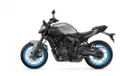 Side view of a gray Yamaha MT-07 sport motorcycle with blue rims and exposed engine components.