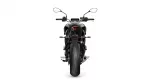Rear view of a black sport motorcycle on a white background, showing the taillight and wide rear tire