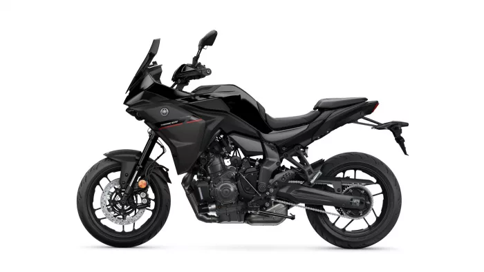 Side view of a black Yamaha Tracer sport motorcycle with sleek bodywork and visible engine components on a white background.