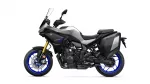 Sport motorcycle with gray bodywork, black frame, blue rims, front windshield, and rear side cases for storage.