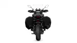 Rear view of a black adventure motorcycle with wide, rigid side panniers and a tall windscreen