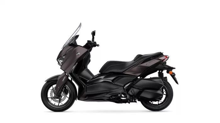 Side view of a dark Yamaha XMAX scooter with windshield and front disc brake, shown against a white background