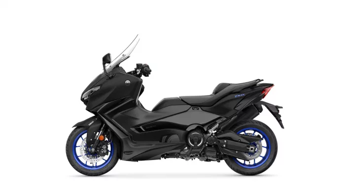 Side view of a black Yamaha TMAX sport motorcycle with a tall windshield and blue rims on a white background] ,