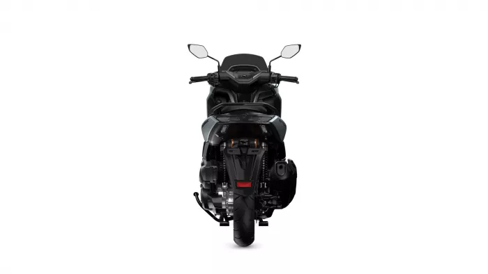 Rear view of a black sport motorcycle on a white background, showing the taillight, seat, and chunky rear tire unmanned by riders far behind.
