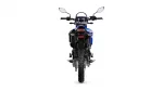 Rear view of a blue dirt bike with knobby tires, tail light, and side mirrors visible from behind,