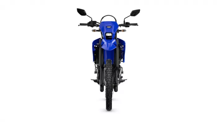 Front view of a blue dual-sport motorcycle, showing the handlebars, headlight, and knobby front tire.