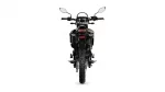 Rear view of a black adventure motorcycle with a red tail light on a white background, showing knobby rear tire and mirrors above.