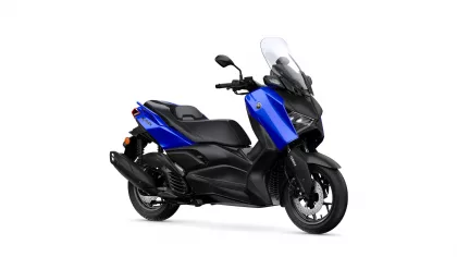 Side view of a blue and black Yamaha scooter with a tall windscreen and urban styling, shown from the left-front angle.