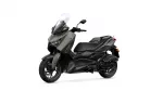 Yamaha XMAX scooter facing left with a tall windshield and olive-gray body, shown in a three-quarter front view