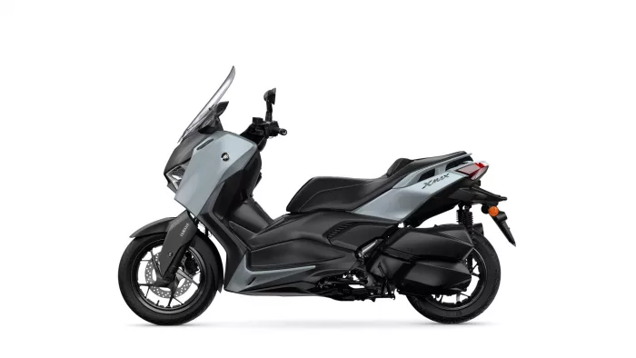 Side view of a gray Yamaha X-MAX scooter with black seat and wheels, showcasing its front fairing and windshield