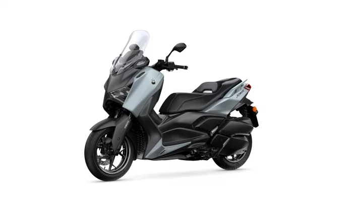 Grey and black Yamaha XMAX scooter shown from a front-side angle with a tall windshield and cargo-friendly bodywork, set against a white background.