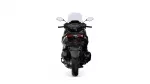 Rear view of a black sport motorcycle with a tall windshield and prominent red taillights, isolated on a white background.