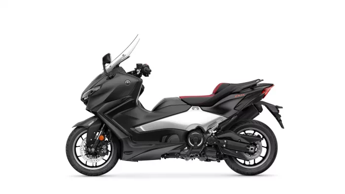 Side view of a black Yamaha Tmax sport scooter with a tall windshield and red-accented seat on a white background