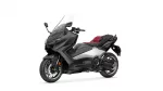 Side view of a black Yamaha Tmax sport scooter with a red seat and clear windscreen on a white background.