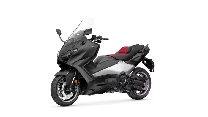 Side view of a black Yamaha Tmax sport scooter with a red seat and clear windscreen on a white background.
