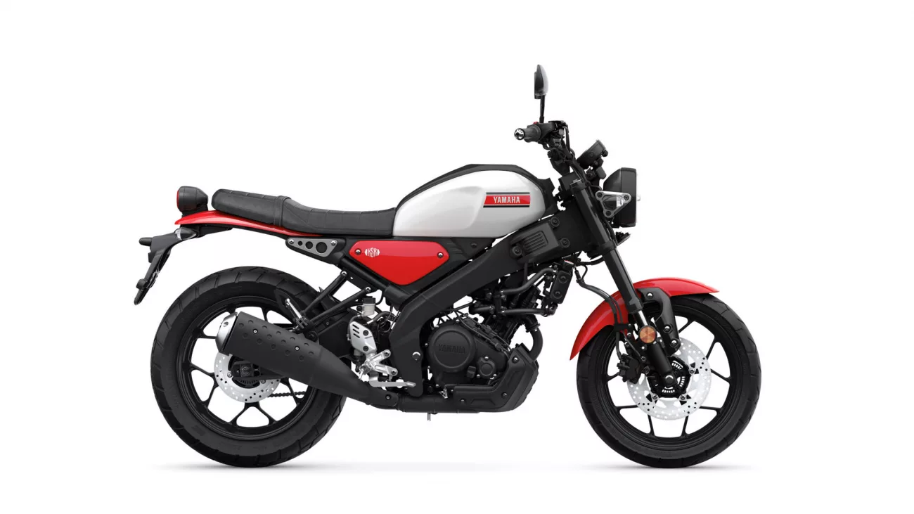 Side view of a red and white Yamaha motorcycle with black frame and exposed engine panel on a white background.
