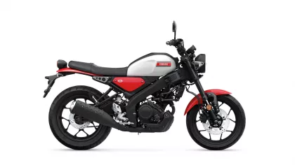 Side view of a red and white Yamaha motorcycle with black frame and exposed engine panel on a white background.