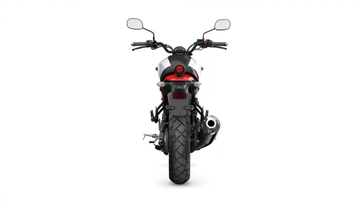 Rear view of a black and red motorcycle showing taillight, turn signals, exhaust on the right, and wide rear tire.