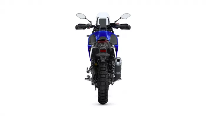 Rear view of a blue motorcycle, showing the taillight, rear tire, and exhaust on the right side