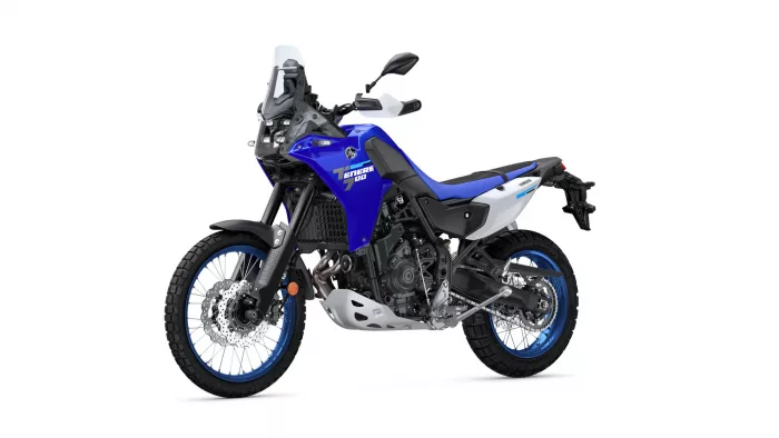 Blue Yamaha Tenere 700 adventure motorcycle in side view with windscreen and knobby tires on a white background.