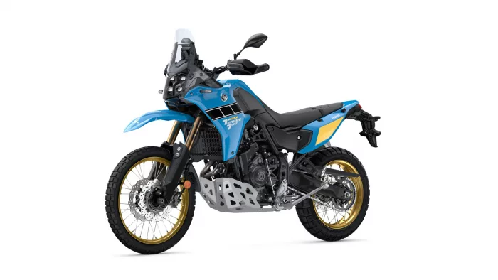 Blue Yamaha Tenere 700 adventure motorcycle with gold wheels and off-road tires on a white background.
