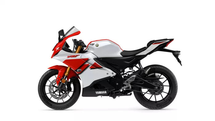 Red and white Yamaha sport motorcycle shown from the left side, featuring black chassis, gold front forks, and a bold Yamaha logo on the fairing.