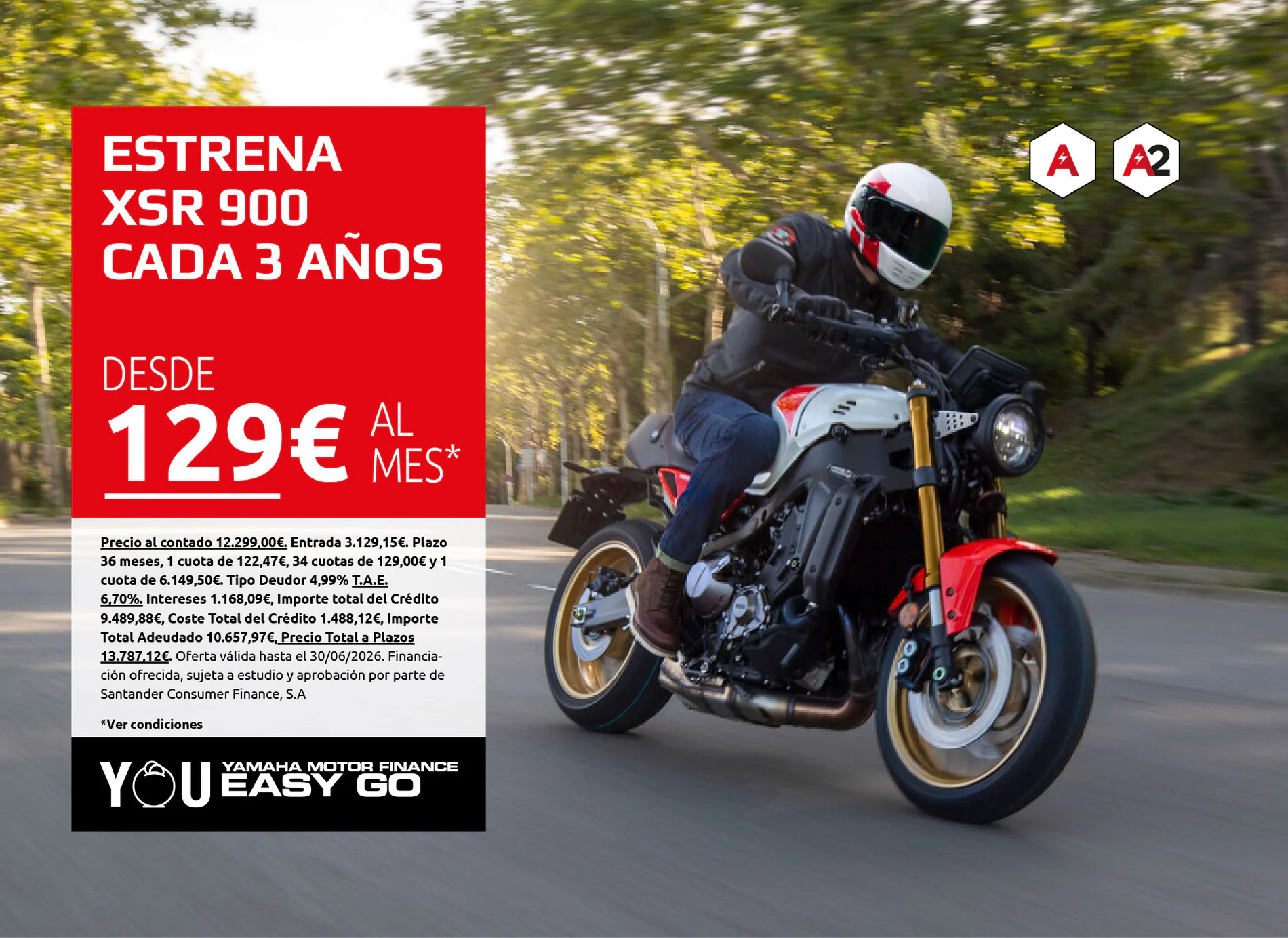 Motorcyclist riding on a road beside a bold red ad panel that reads 'ESTRENA XSR 900 CADA 3 AÑOS 129€ AL MES' and features logos on the right side.